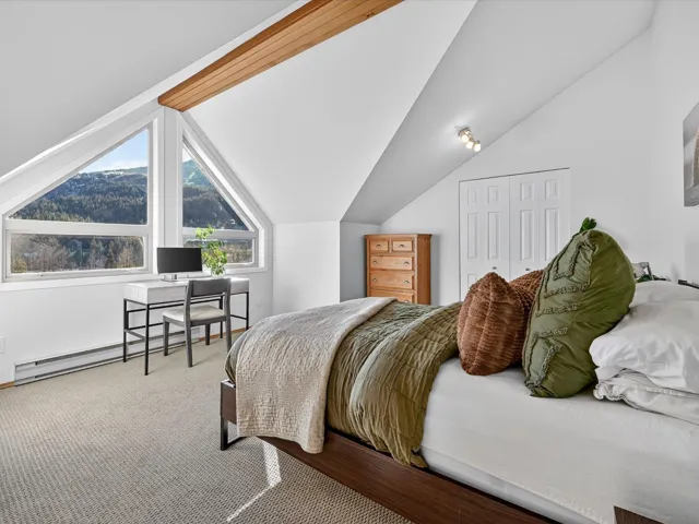 Carpeted bedroom featuring lofted ceiling and a closet