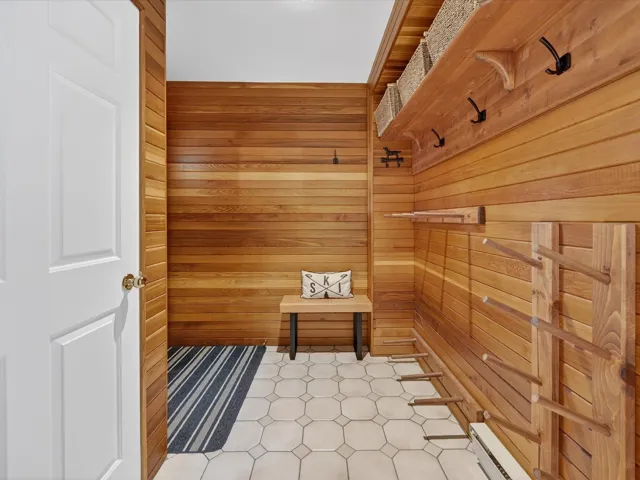 Mudroom featuring wooden walls, a sauna / steam room, light flooring, and baseboard heating