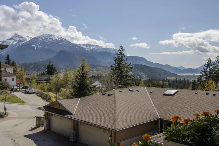 Covered balcony with wood railings and snow-capped mountain scenery