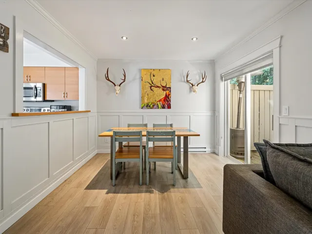 Dining area featuring a decorative wall, light wood finished floors, ornamental molding, wainscoting, and recessed lighting
