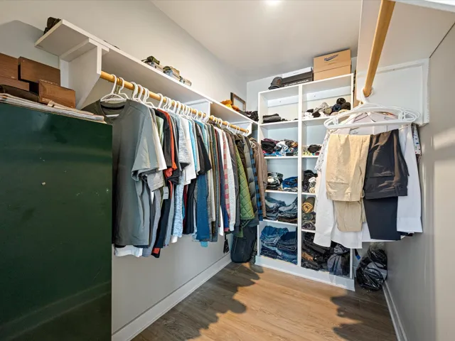 Spacious closet featuring light wood-style flooring