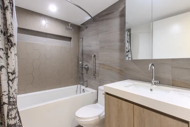 Entryway featuring light wood-finish flooring, a wall-mounted mirror with a wood frame, and a built-in coat rack