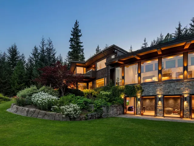 Rear view of house with a lawn and stone siding