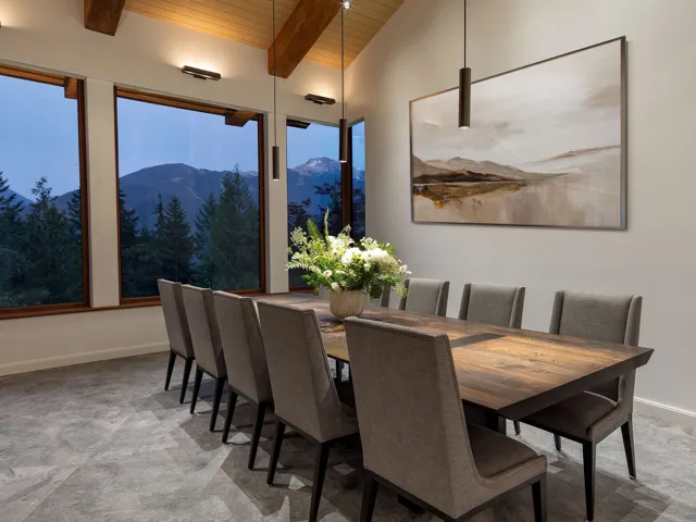 Dining room featuring a mountain view, a wooden ceiling with exposed beams, and light colored carpet