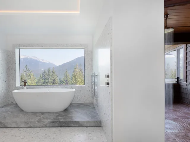 Full bath with a freestanding tub, a mountain view, and tile walls