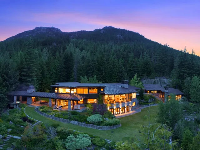 Rear view of property with a chimney, a standing seam roof, a metal roof, a patio, and a lawn