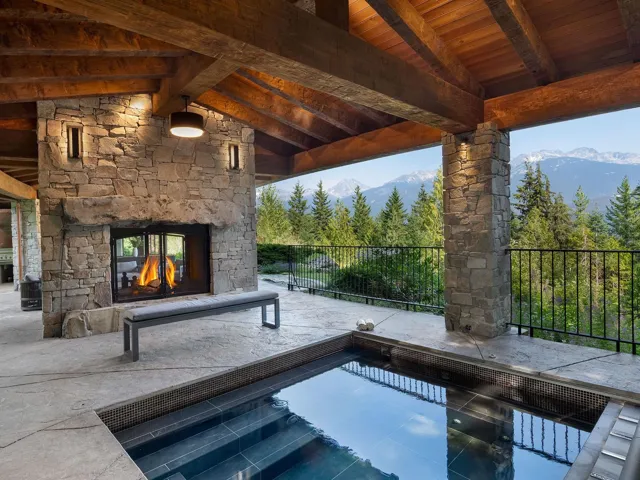 View of patio / terrace with a mountain view and an outdoor stone fireplace