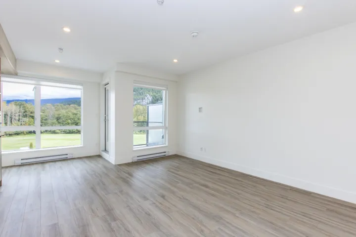 Unfurnished room with light wood-type flooring, a baseboard radiator, and recessed lighting