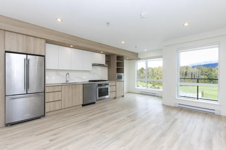 Kitchen with open shelves, light brown cabinets, appliances with stainless steel finishes, baseboard heating, and light wood-style floors