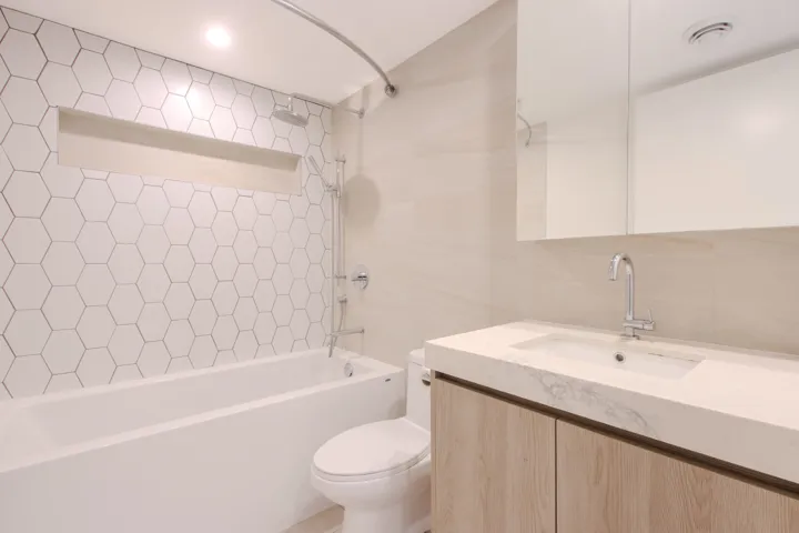 Full bathroom featuring bathtub / shower combination, vanity, and tile walls