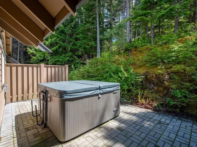 Outdoor patio featuring a hot tub with cover, paver stone flooring, and a privacy fence