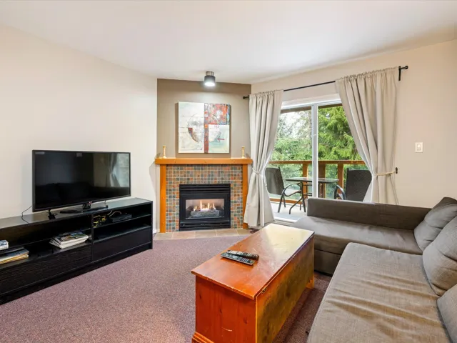 Living area with a tile fireplace and carpet flooring