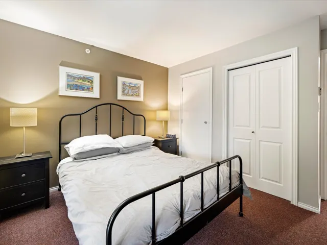 Bedroom with dark colored carpet and a closet