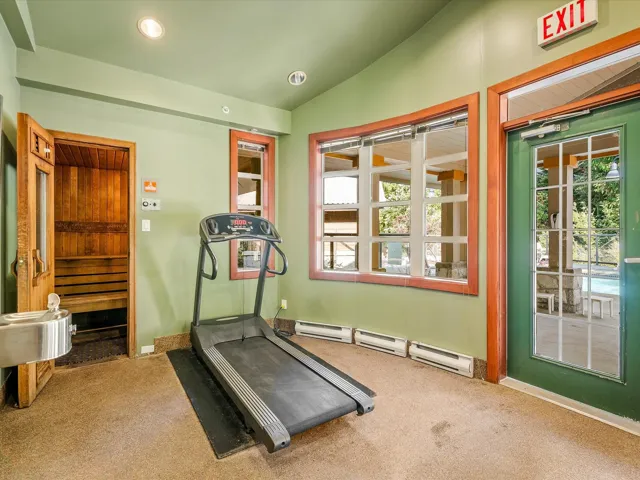 Workout area featuring lofted ceiling, baseboard heating, a relaxing sauna, and recessed lighting