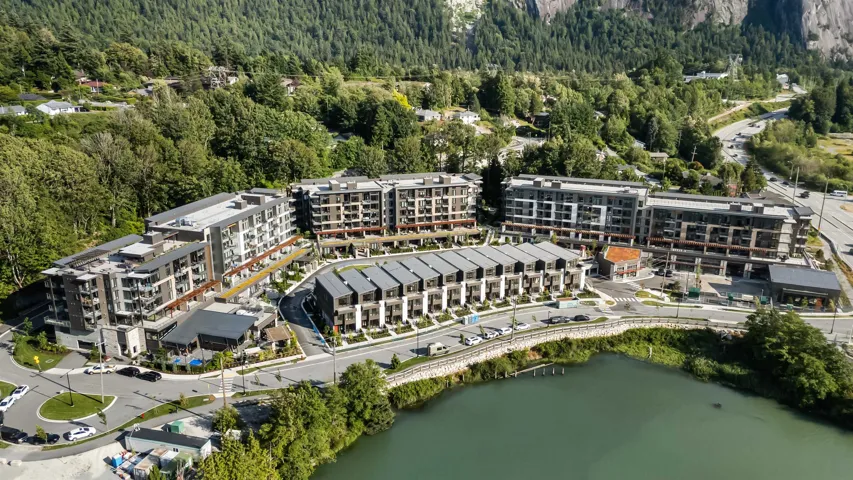 Modern multi-story buildings and townhomes feature contemporary architecture with balconies and dark-pitched roofs