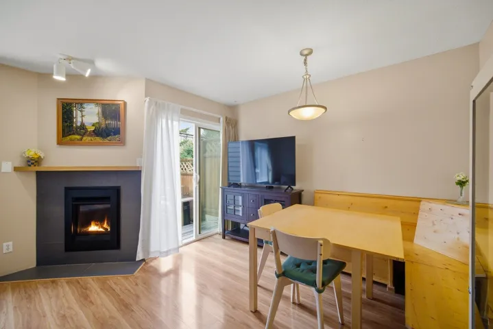 Dining space with wood finished floors and a fireplace with flush hearth