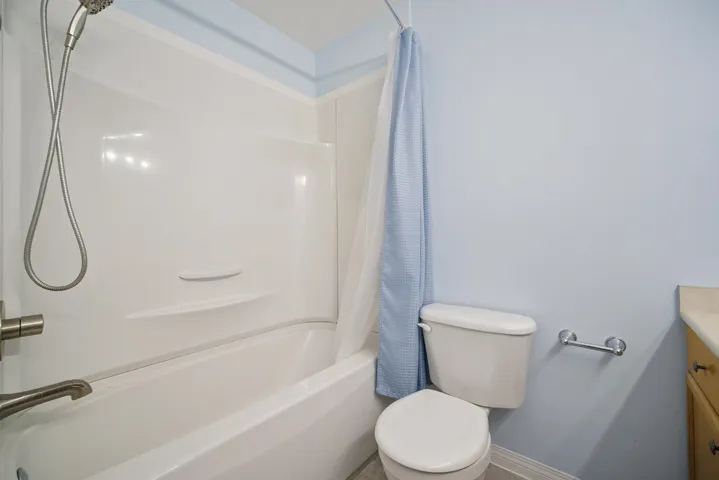 Full bathroom with shower / bath combo with shower curtain and toilet