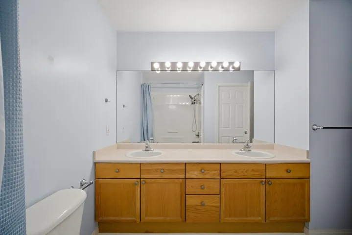 Laundry area with light wood-type flooring, baseboard heating, and hookup for an electric dryer