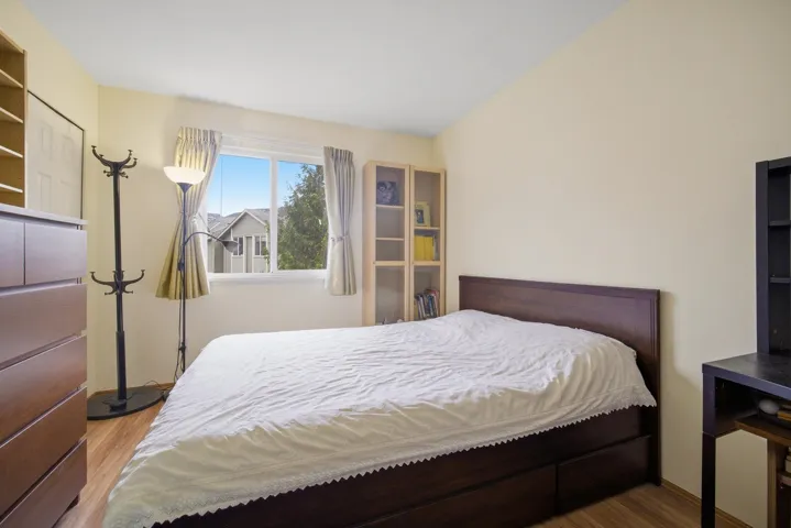 Bedroom featuring wood finished floors and vaulted ceiling