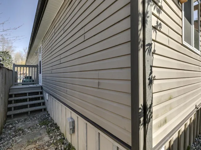 View of side of home featuring a wooden deck and crawl space