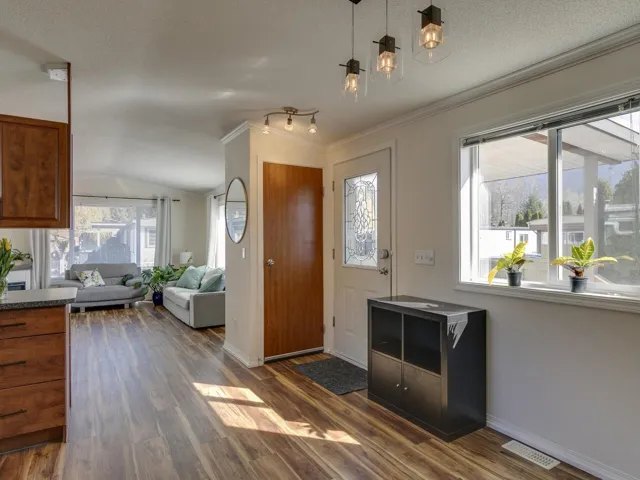 Foyer entrance with dark wood-style floors and ornamental molding