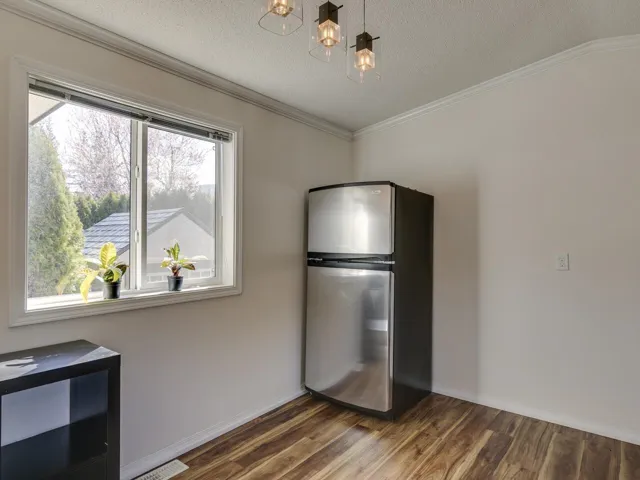 Unfurnished dining area with dark wood-type flooring, crown molding, and a textured ceiling