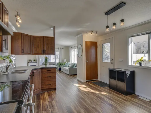 Kitchen featuring stainless steel electric range, ornamental molding, dark wood-style flooring, rail lighting, and a peninsula