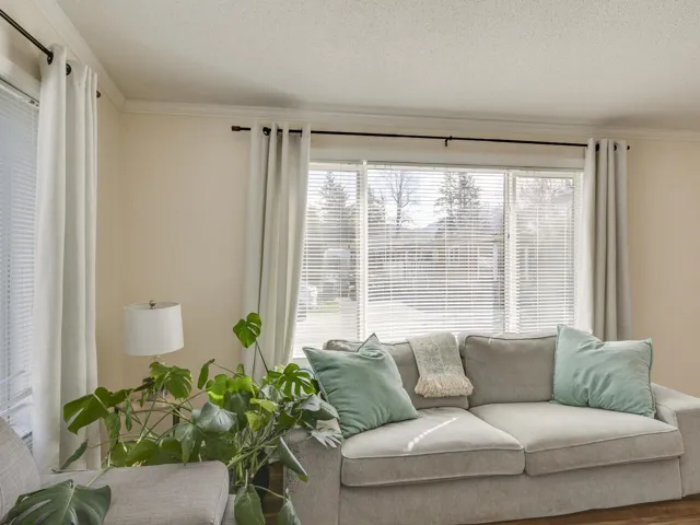 Living area with ornamental molding, a textured ceiling, and wood finished floors
