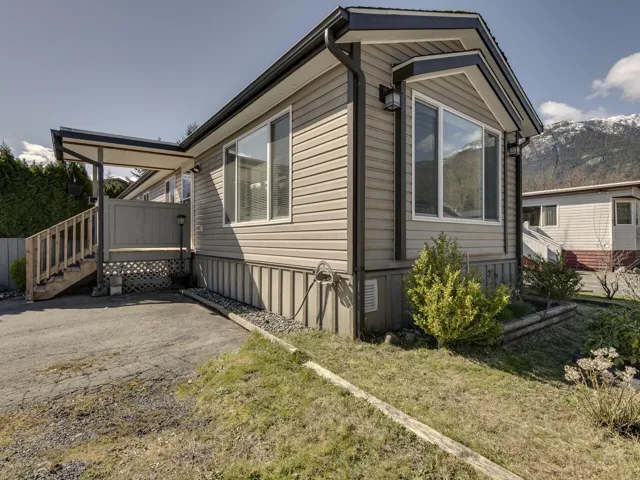 View of side of property with a deck with mountain view and a yard