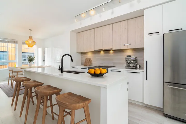 Kitchen featuring freestanding refrigerator, a sink, modern cabinets, and a breakfast bar