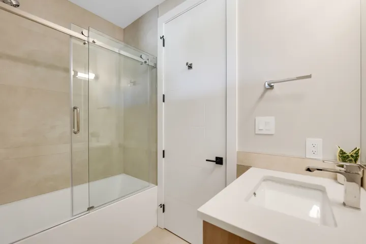 Bathroom featuring vanity and enclosed tub / shower combo
