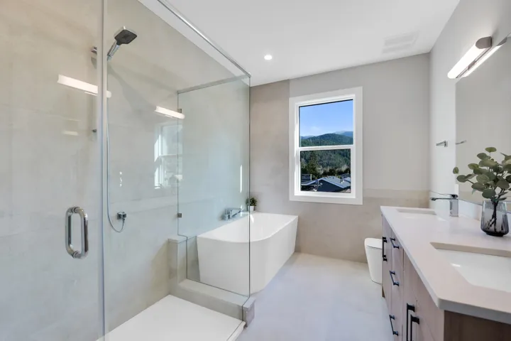 Full bath featuring a soaking tub, double vanity, a shower stall, tile walls, and recessed lighting