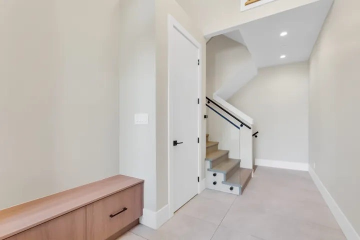Stairs with recessed lighting and tile patterned flooring
