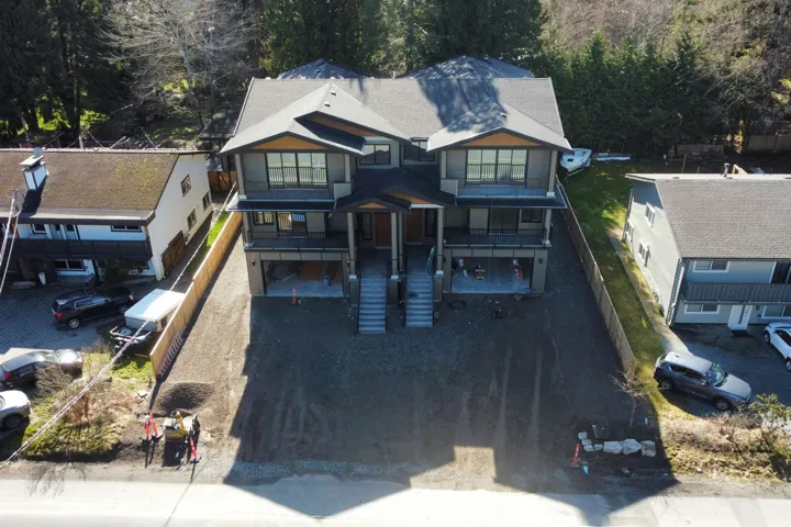 View of front of home with a garage, a balcony, a deck, and driveway