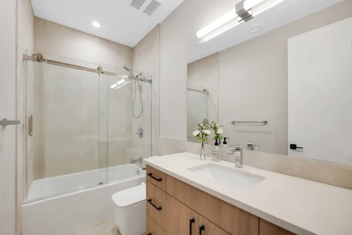 Bathroom with vanity and combined bath / shower with glass door