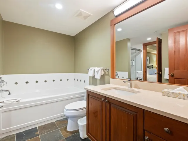 Bathroom with vanity, a garden tub, recessed lighting, a stall shower, and stone tile flooring