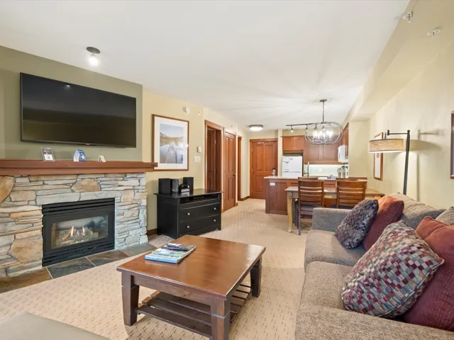 Living room featuring light carpet, a fireplace, and a chandelier