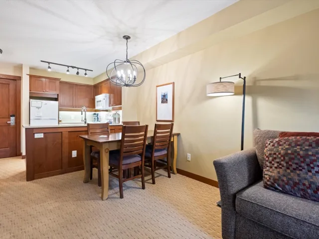 Dining space featuring light carpet, a chandelier, and track lighting