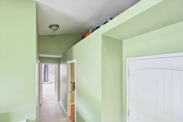 Corridor featuring light carpet