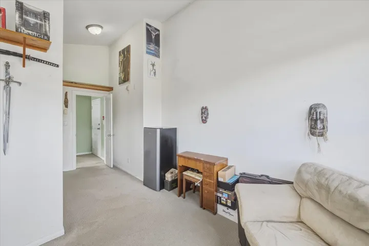 Corridor featuring light colored carpet and baseboards
