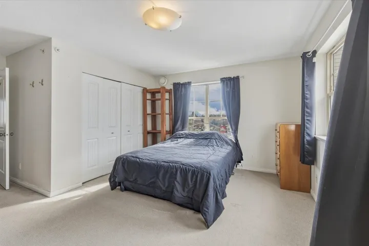 Carpeted bedroom with baseboards and a closet