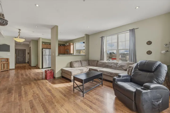 Living room with light wood-type flooring and recessed lighting