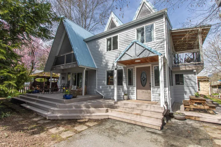 View of front of house featuring a balcony and a metal roof