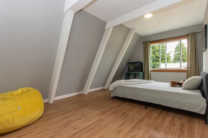 Bedroom with light wood-type flooring and vaulted ceiling