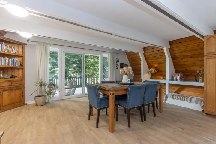 Dining area with light wood-style flooring and wood walls