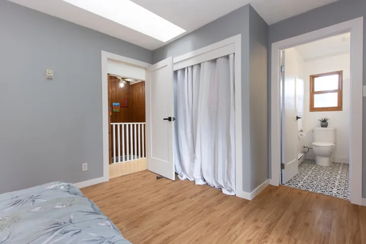 Bedroom with light wood-type flooring and a skylight