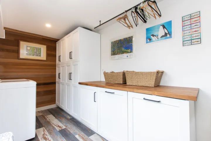 Laundry featuring washer / clothes and plenty of cabinet space, wood wall finish and recessed lighting