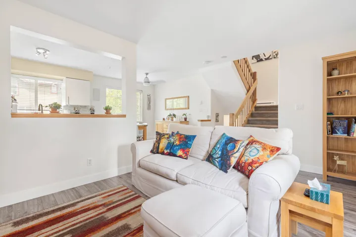 Living area with wood finished floors, plenty of natural light, and stairway