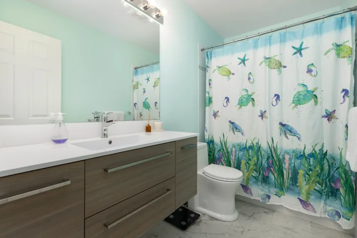 Bathroom featuring marble finish flooring, vanity, and a shower with shower curtain