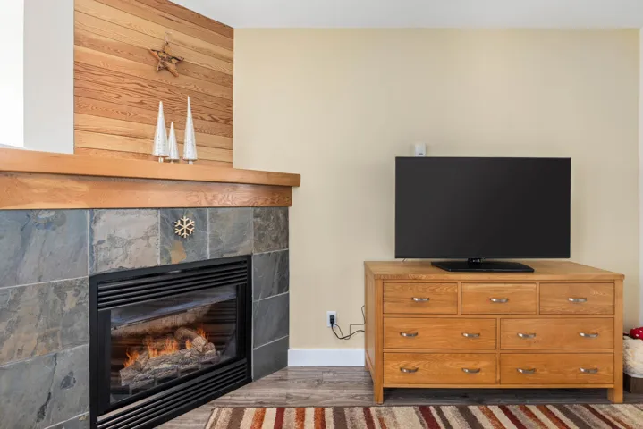 Living room with a tile fireplace and wood finished floors